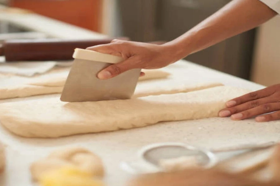 Stainless steel blades cutting through thick pastry dough