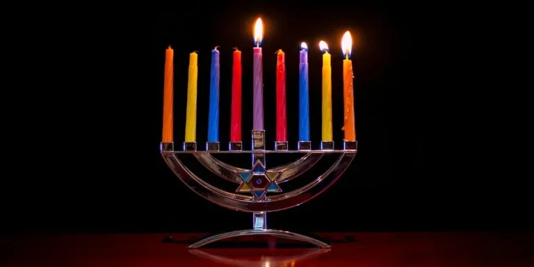 Standard menorah candles in different colors lit up at night