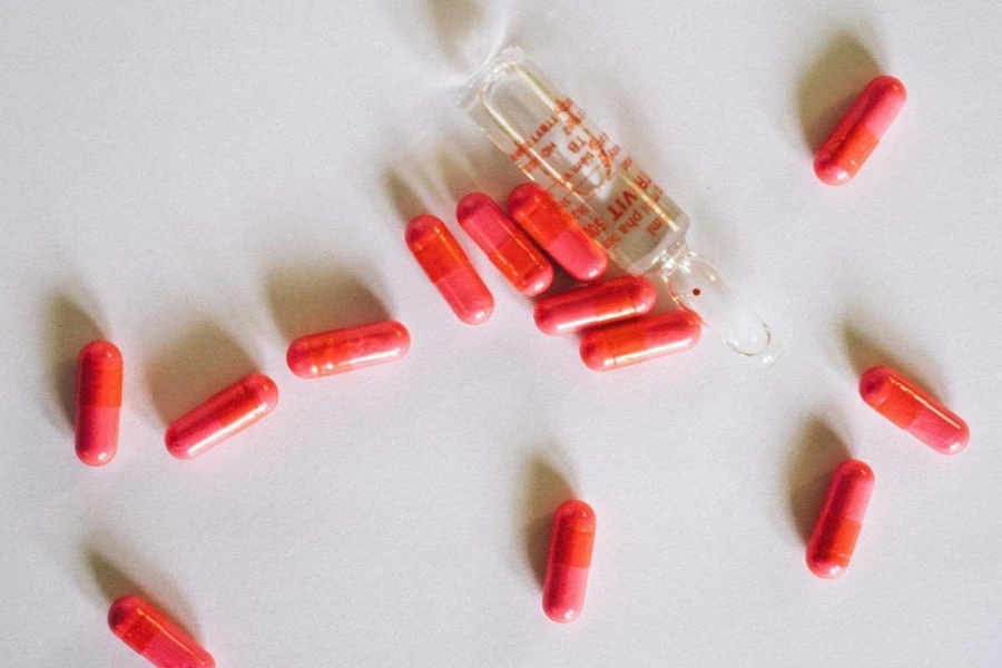 Top View of Red Pills Scattered on White Background