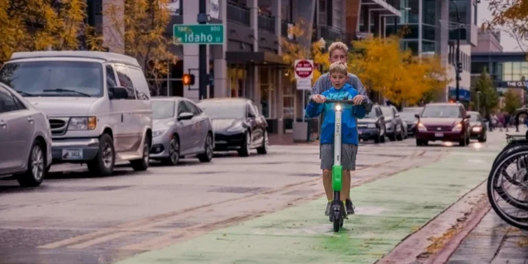 Dua Anak Laki-laki Mengendarai Skuter Lime di Jalan