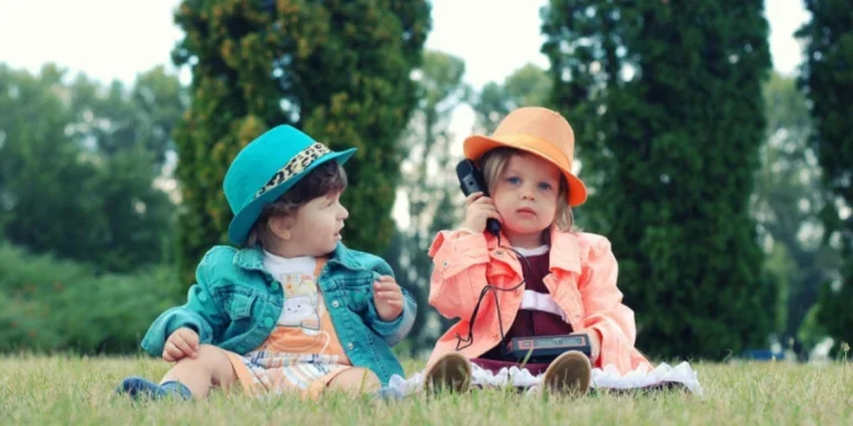Two Toddlers Sitting on Grass Field