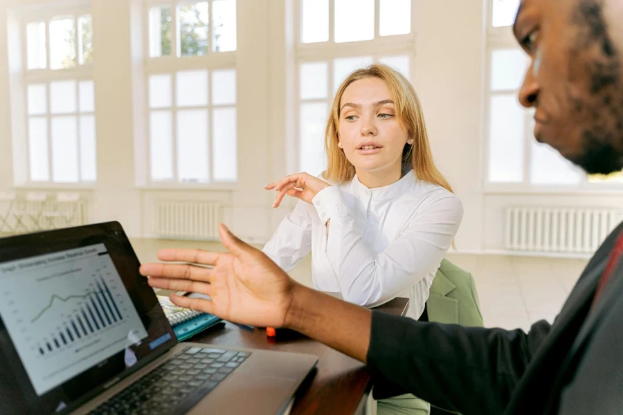 Two colleagues discussing analytics on a laptop
