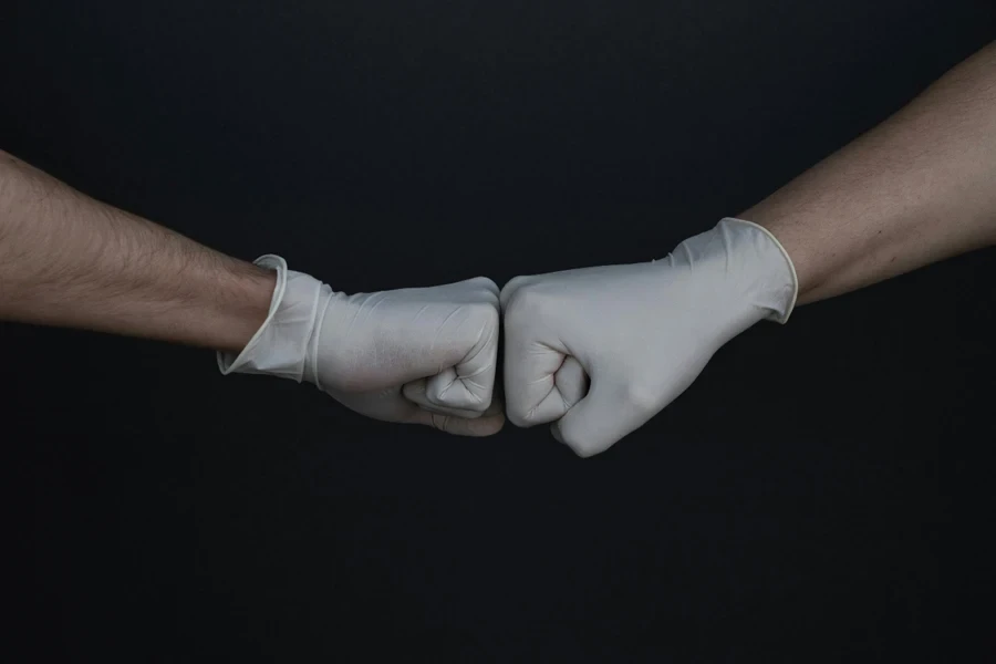 Two hands in gloves making fist bump