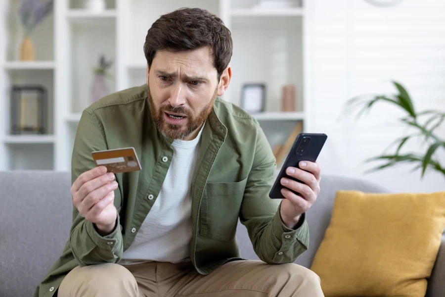 Upset man feeling cheated while shopping online