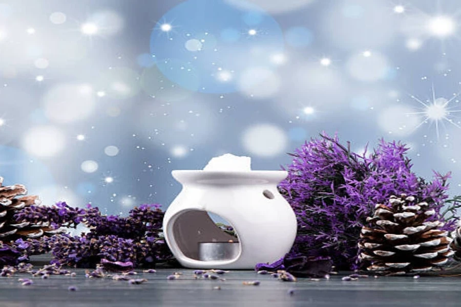 White ceramic wax melter with winter decorations around it