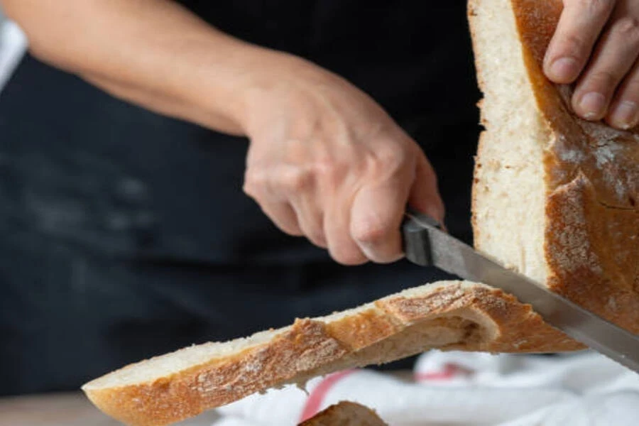 Woman holding knife with serrated blade and loaf