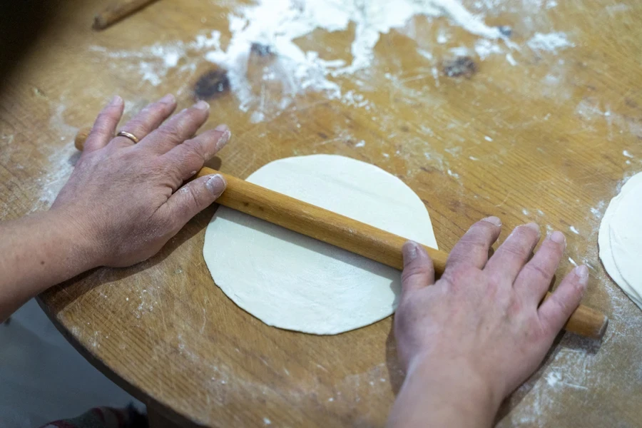 Woman rolling dough with a small rolling pin