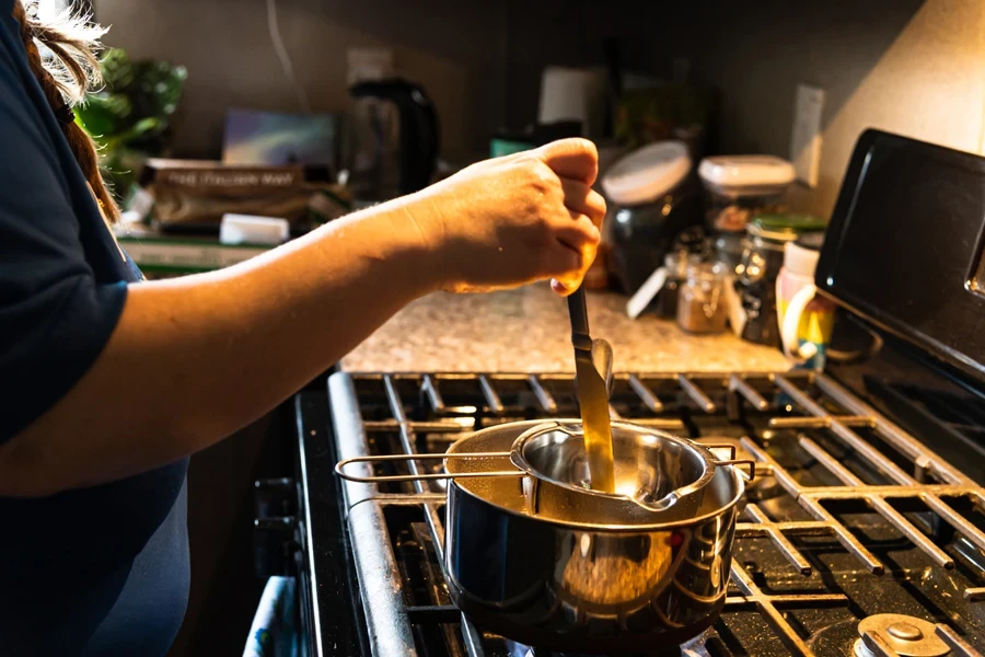 Woman stirring contents in a double boiler