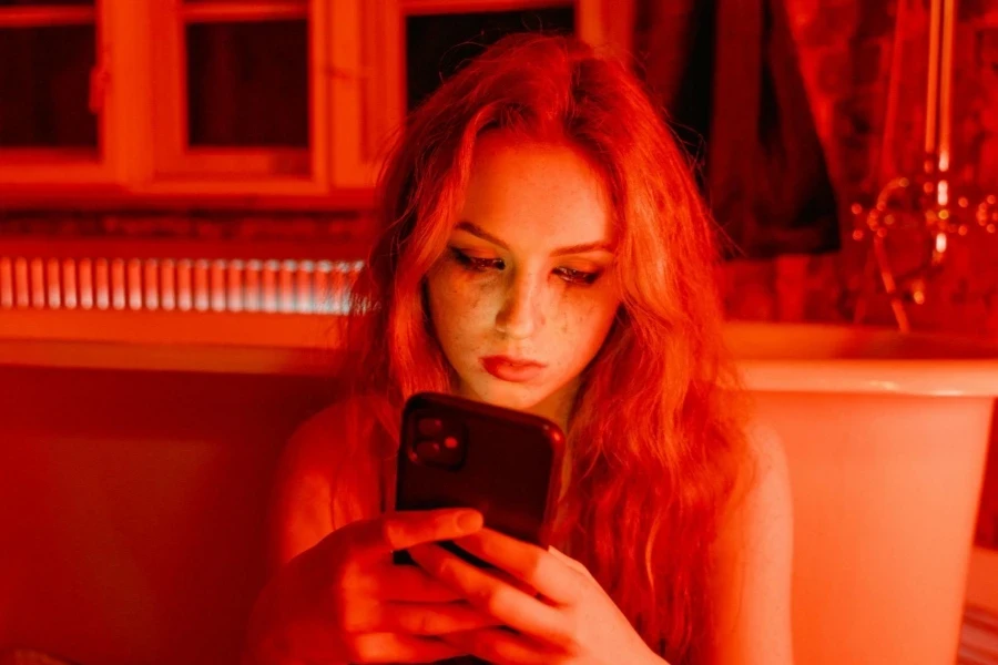 Woman with Smudge on Face Holding Cellphone