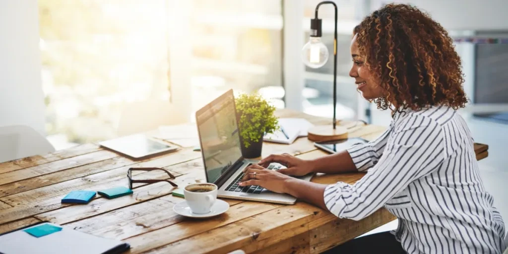 Woman writing an email on a wooden desk
