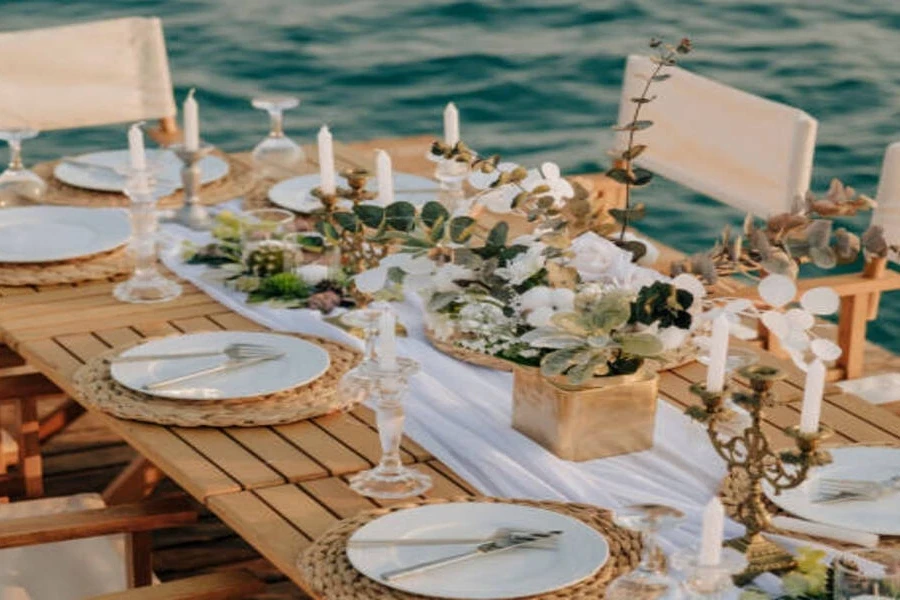 Wooden dining table setup next to edge of sea