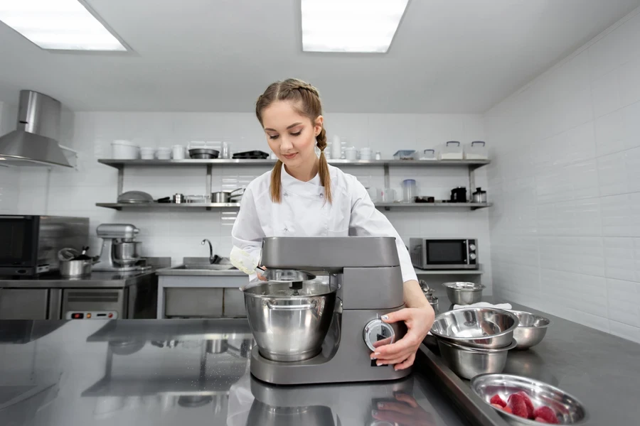 A chef adjusting the speed options of an electric whisk