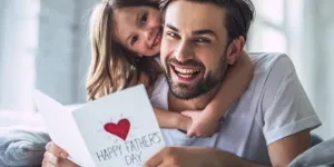A daughter and dad holding a greeting card