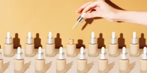 A female hand over different bottles of skin tint