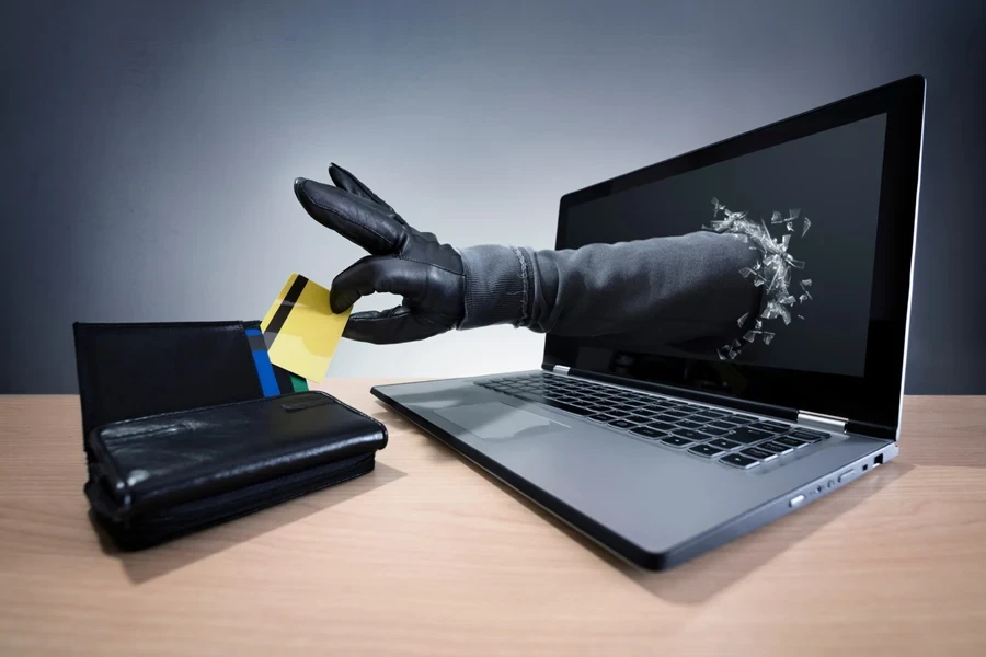 A hand from a laptop stealing money