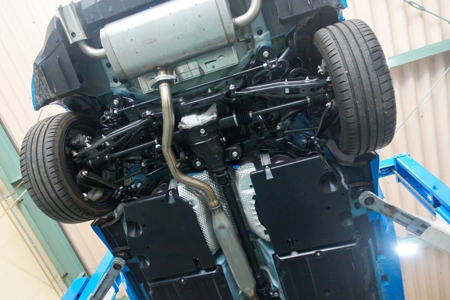 A lifted car showing the rear wheels and control arms