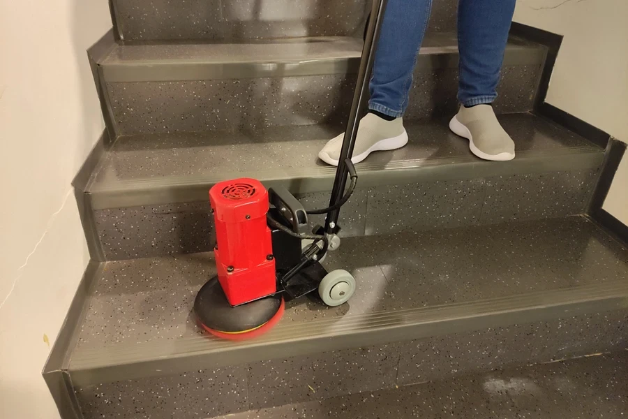 A man cleaning with a red cordless electric spin scrubber