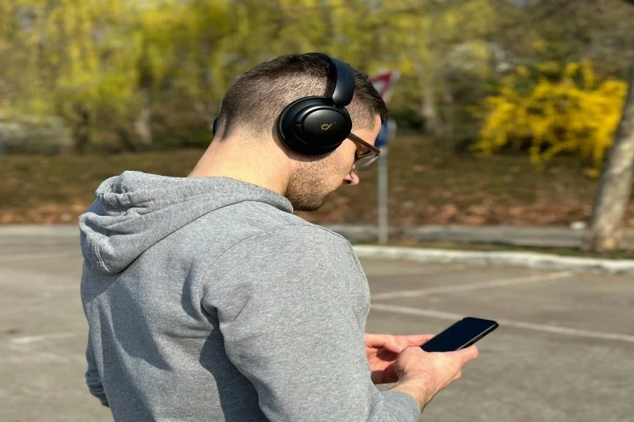 A man wearing headphones looking at a phone