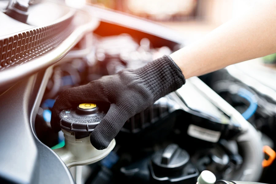 A mechanic opening the brake fluid reservoir in a car