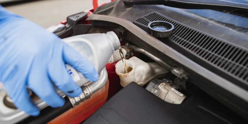 A person adding brake fluid to a vehicle