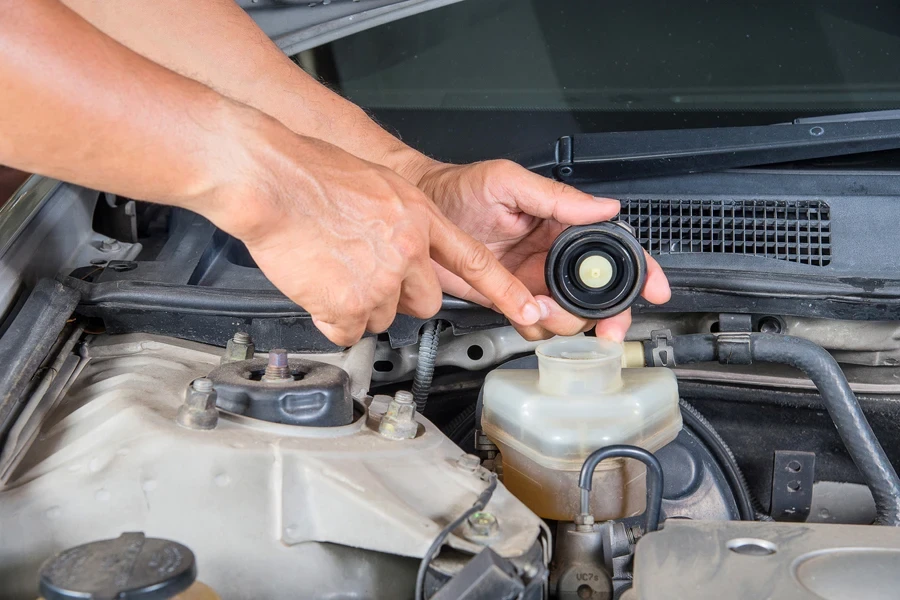 A person checking brake fluid levels