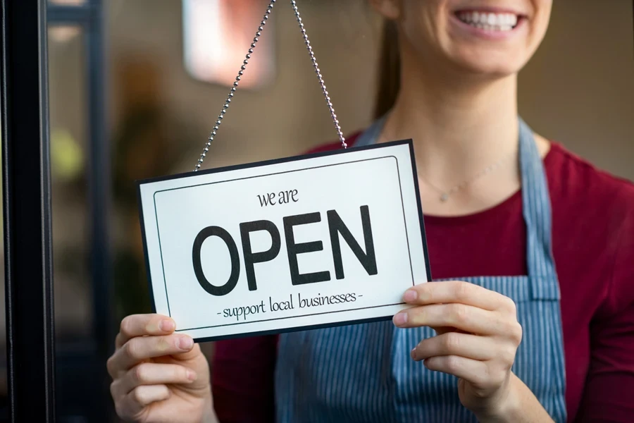 A small business owner flipping the open sign