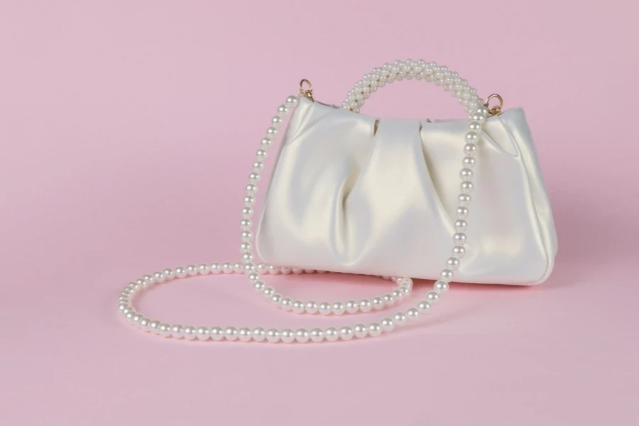 A white purse with a beaded handle
