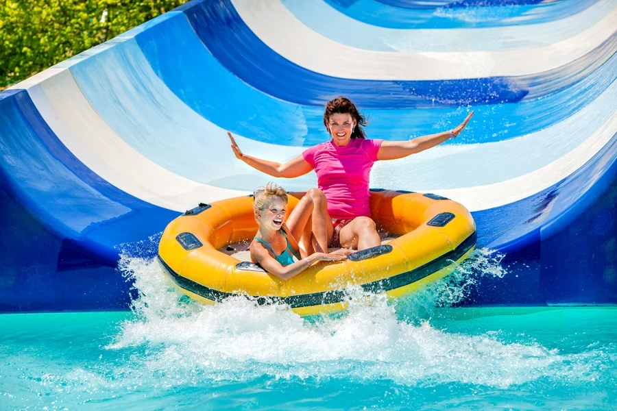 A woman and child having fun on a pool slide
