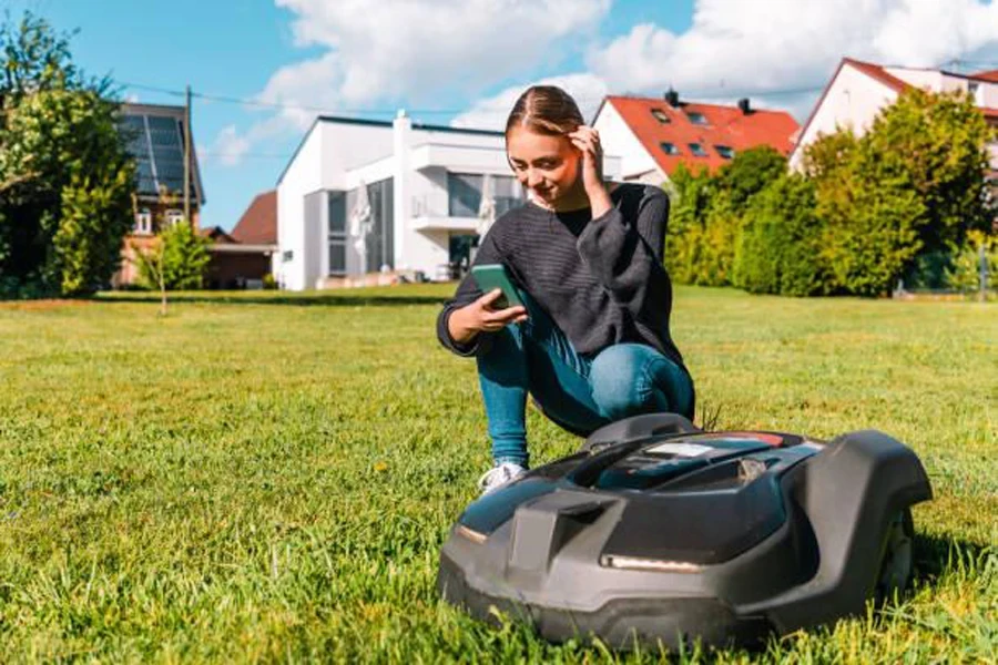 A woman connecting her smartphone to an AI lawnmower
