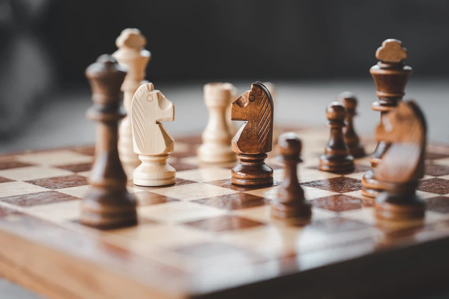 A wooden chess board with wooden pieces