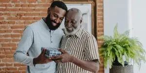 Adult son giving gift to senior father