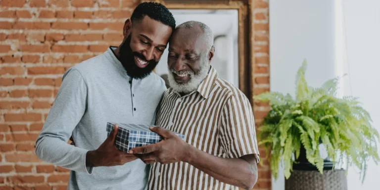 Adult son giving gift to senior father