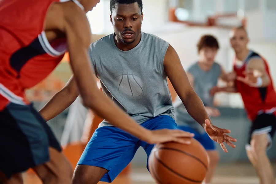 Amateur men’s basketball game being played on indoor site