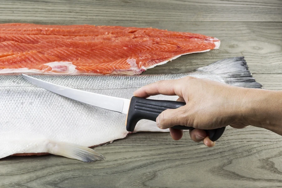 Boning knife used on fillet of fish on counter