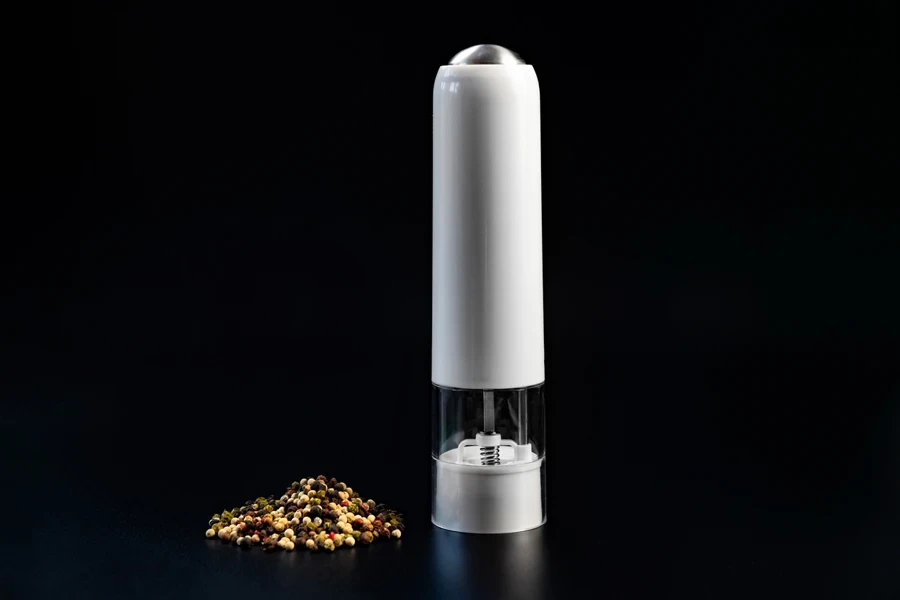 Button-operated electric pepper grinder with white handle and base