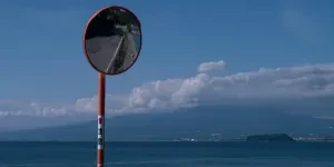 Curved convex mirror placed on road next to sea
