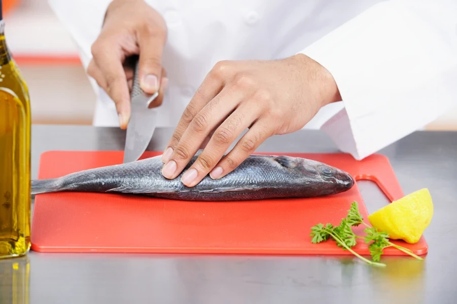 Deba knife with wide blade being used by chef