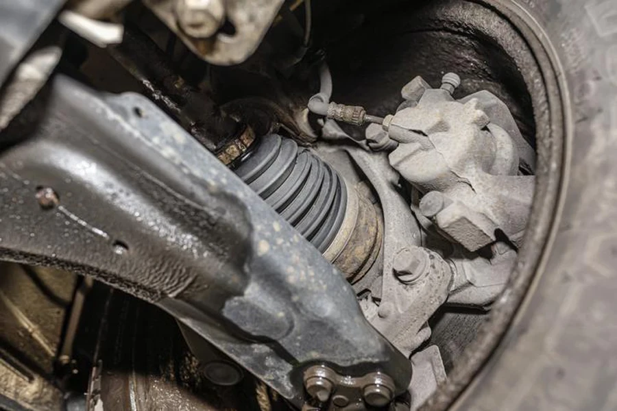 Front drive shaft inside the vehicle, with visible elements of the steering system, viewed from underneath the lifted vehicle