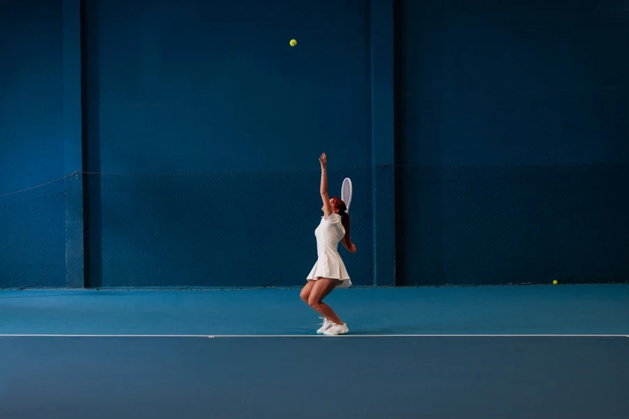 Girl serving on edge of court with matching shoes