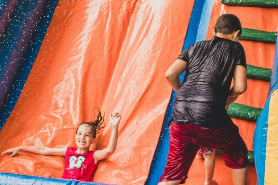 Kids playing in a colorful inflatable pool slide