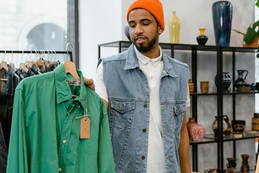 Man holding a green long-sleeved shirt