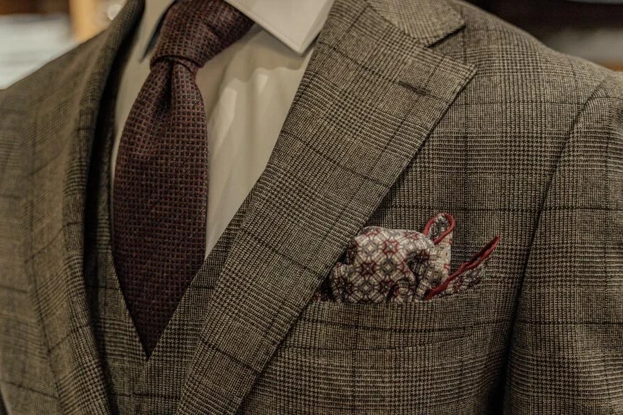Man in a grey checkered suit and patterned tie