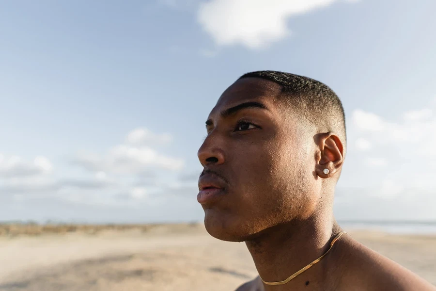 Man wearing gold snake chain necklace on the beach