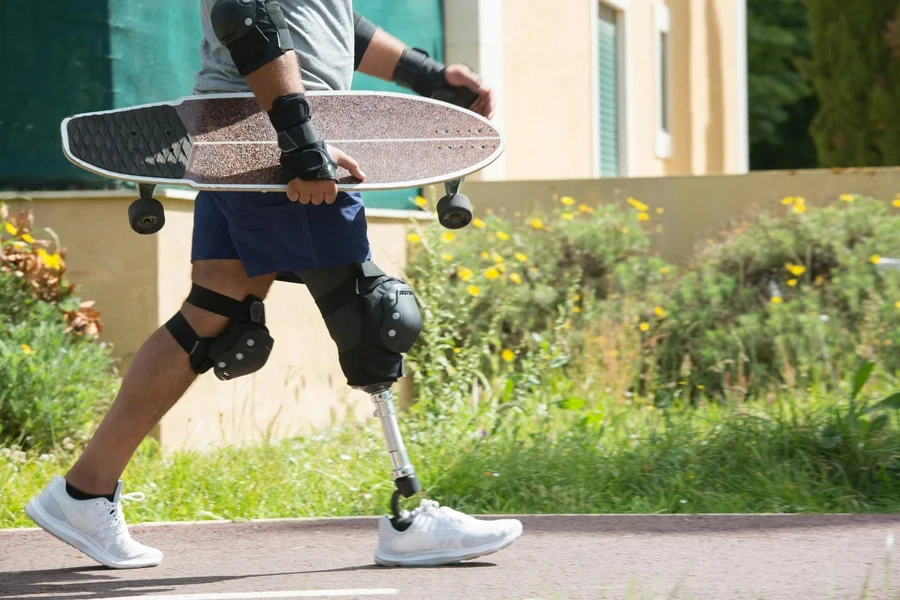 Man with prosthetic leg confidently holding skateboard during a sunny day in Portugal