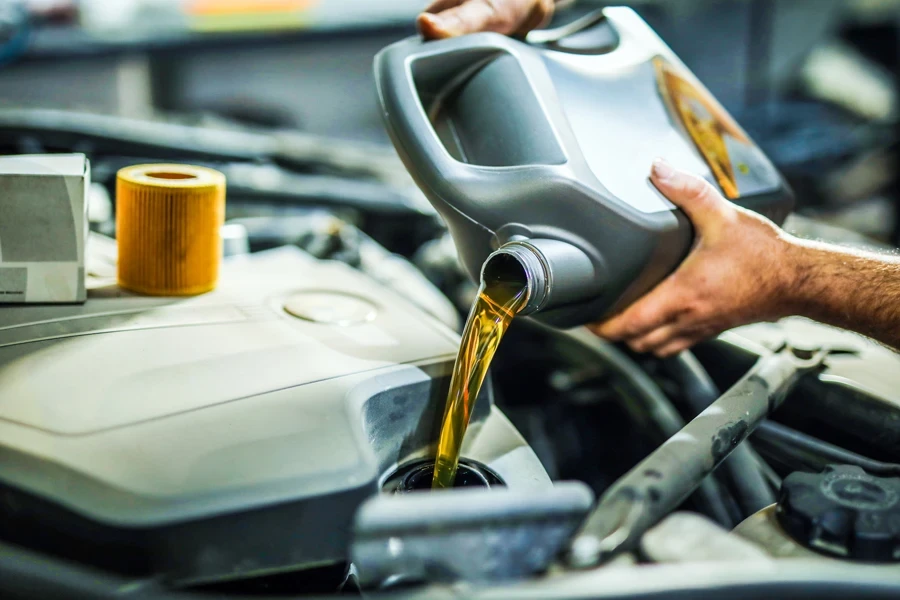 Mechanic adding oil to an engine