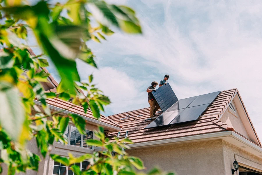 Men installing solar panel on roof