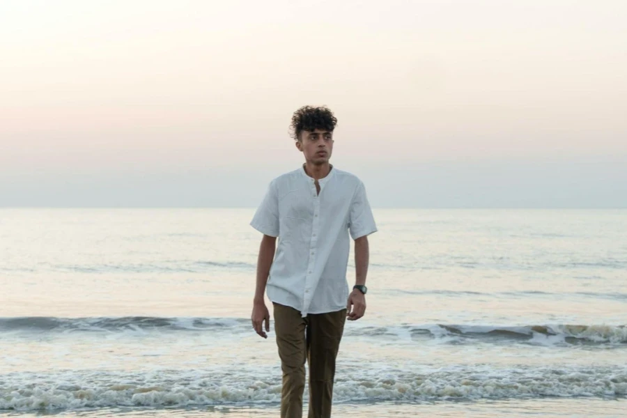 Model in a White Short Sleeved Shirt with the Sea at Dawn in the Background