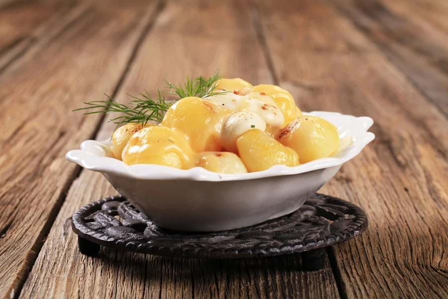 Mozzarrella cheese and potatoes placed on a metal trivet