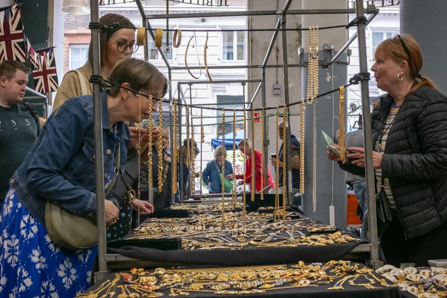 People looking for jewelry gifts among gold necklaces