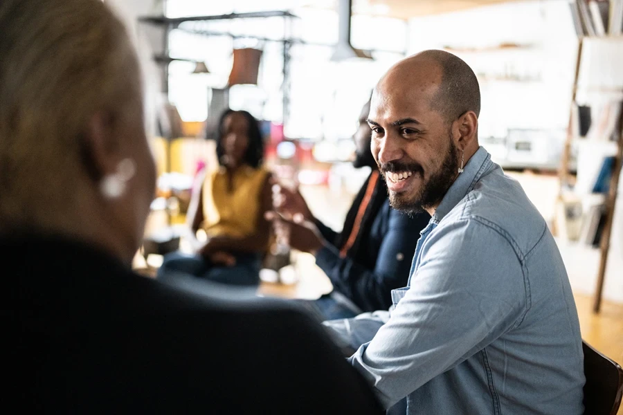 People smiling and talking about their experiences